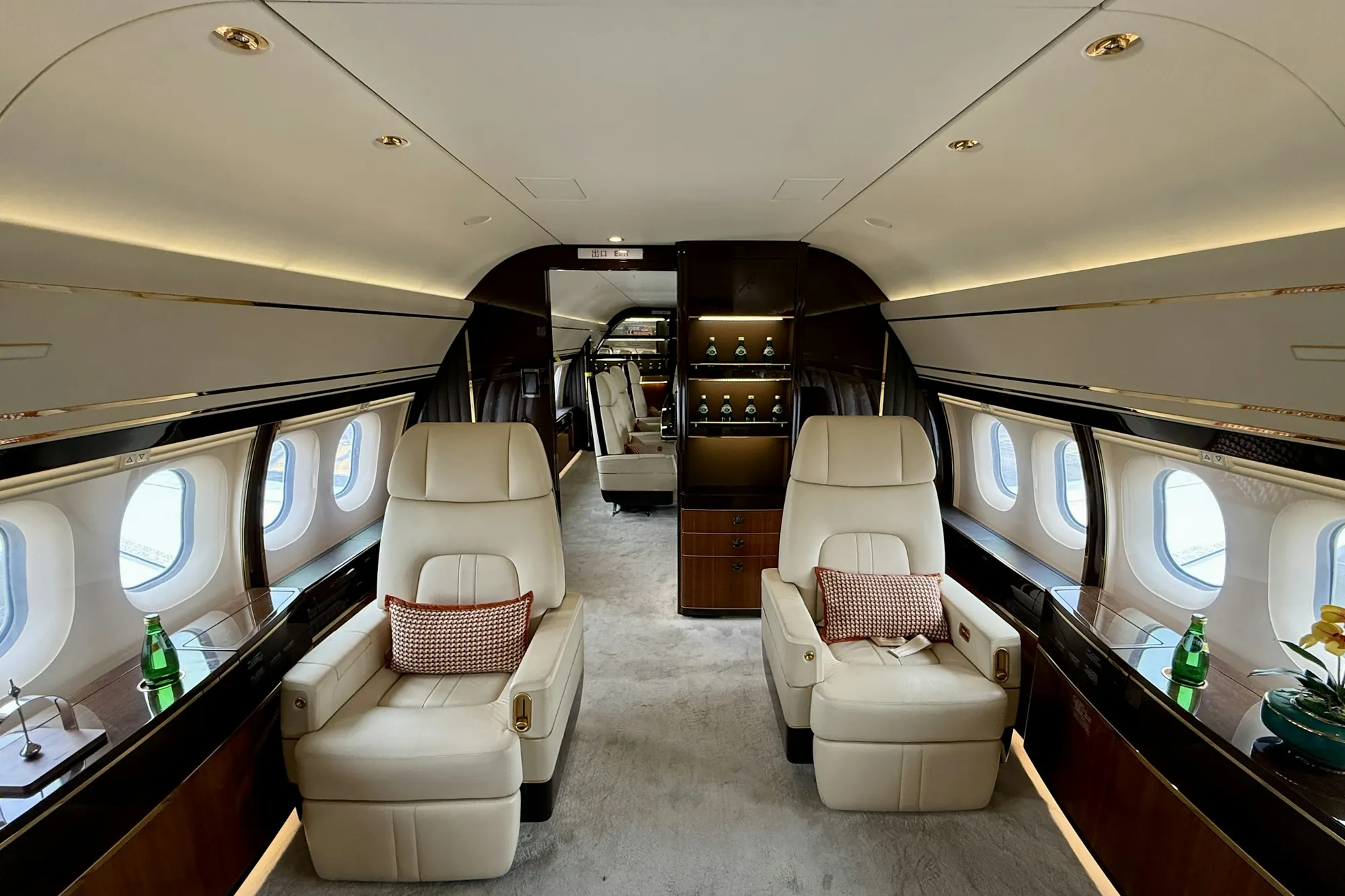 Wide cabin of a large private jet with cream leather seats