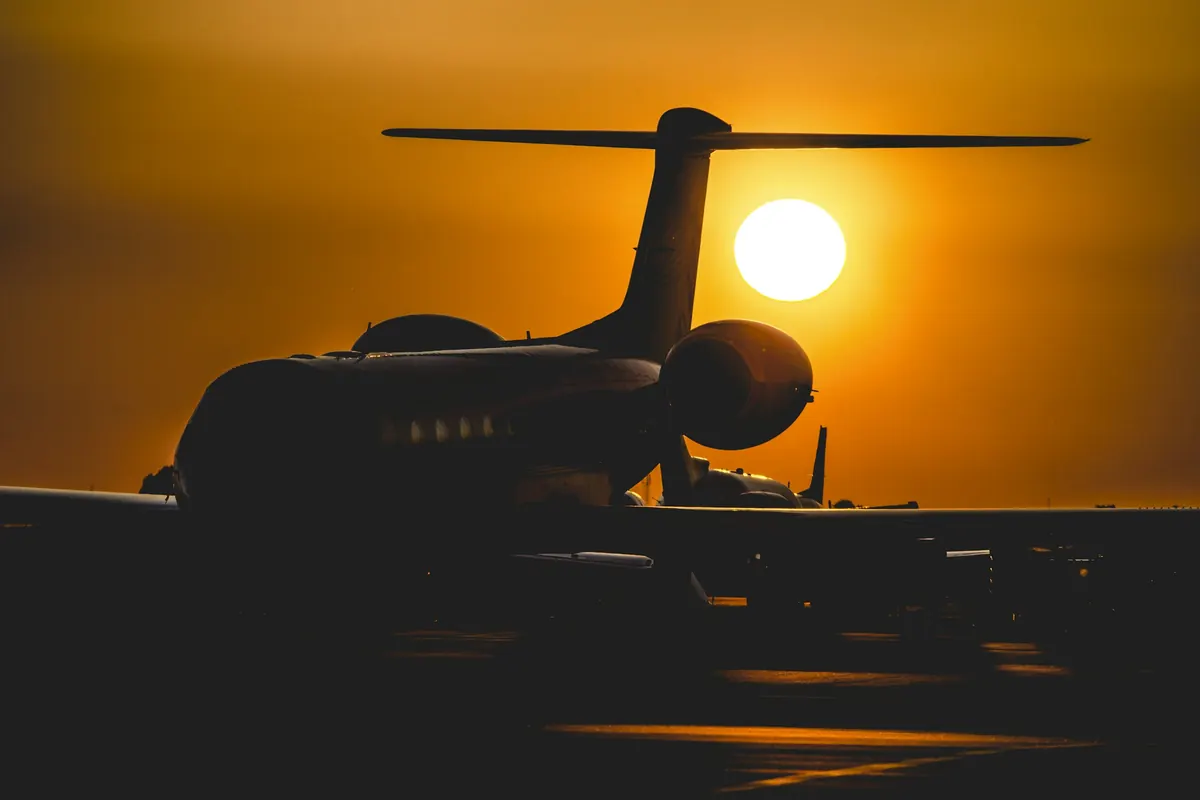 Business jet silhouetted against a low setting sun