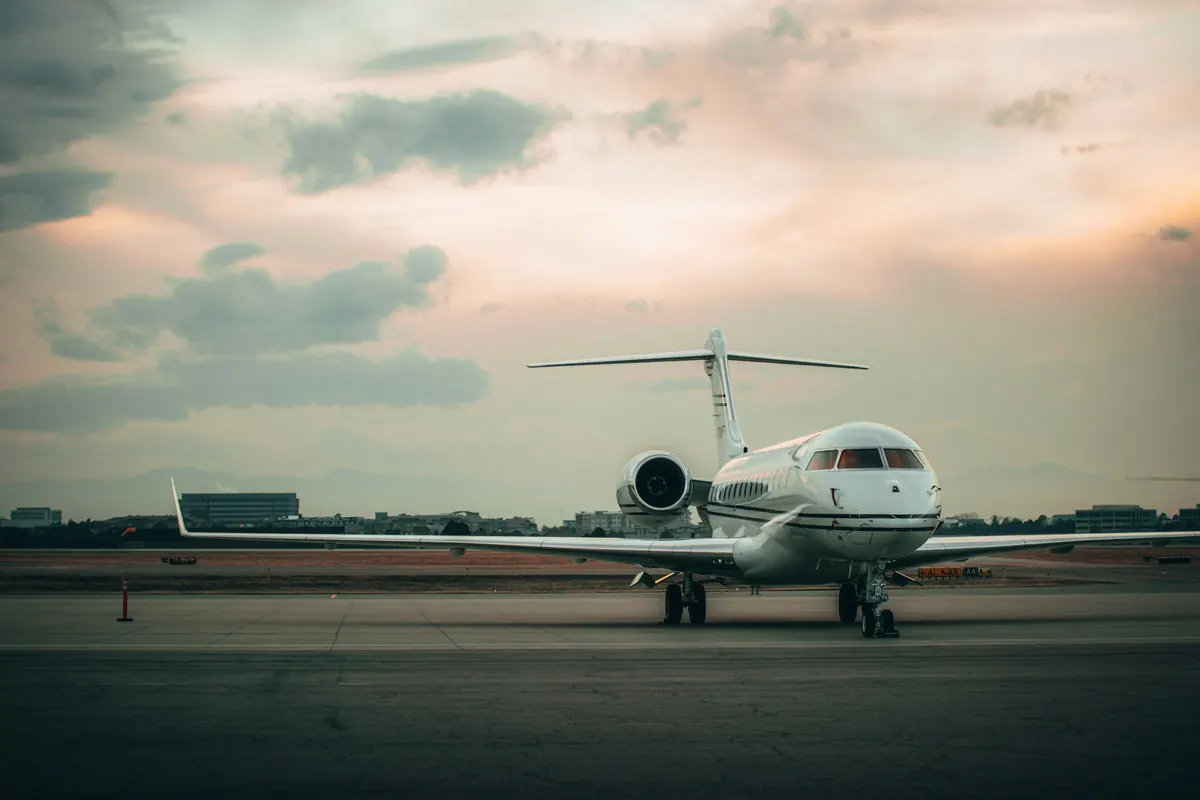 Business jet parked on a wide ramp under a dusk sky