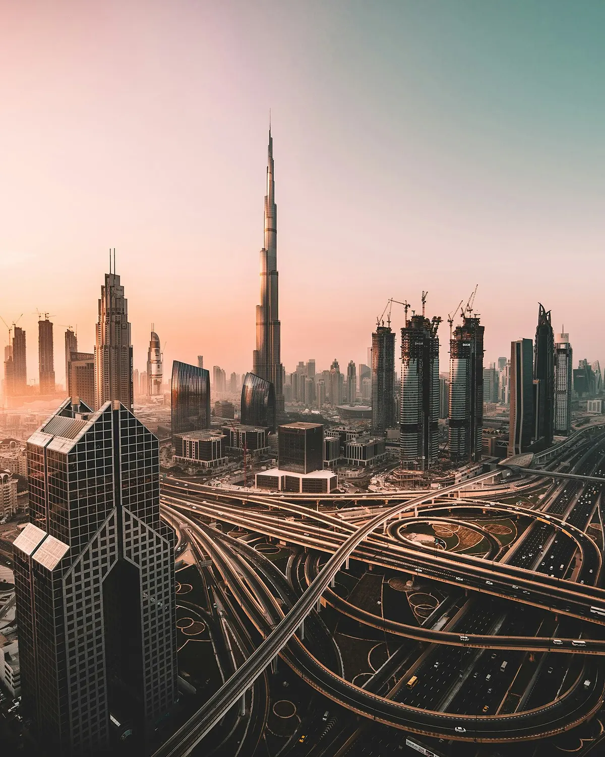 Dubai skyline at sunrise above a highway interchange