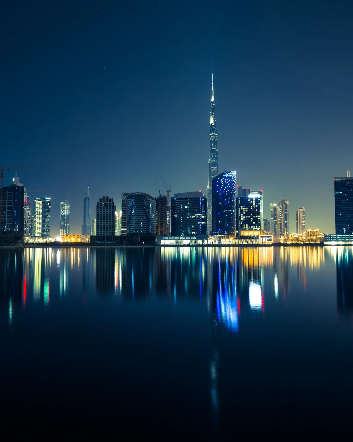 Dubai skyline reflected in still water at night